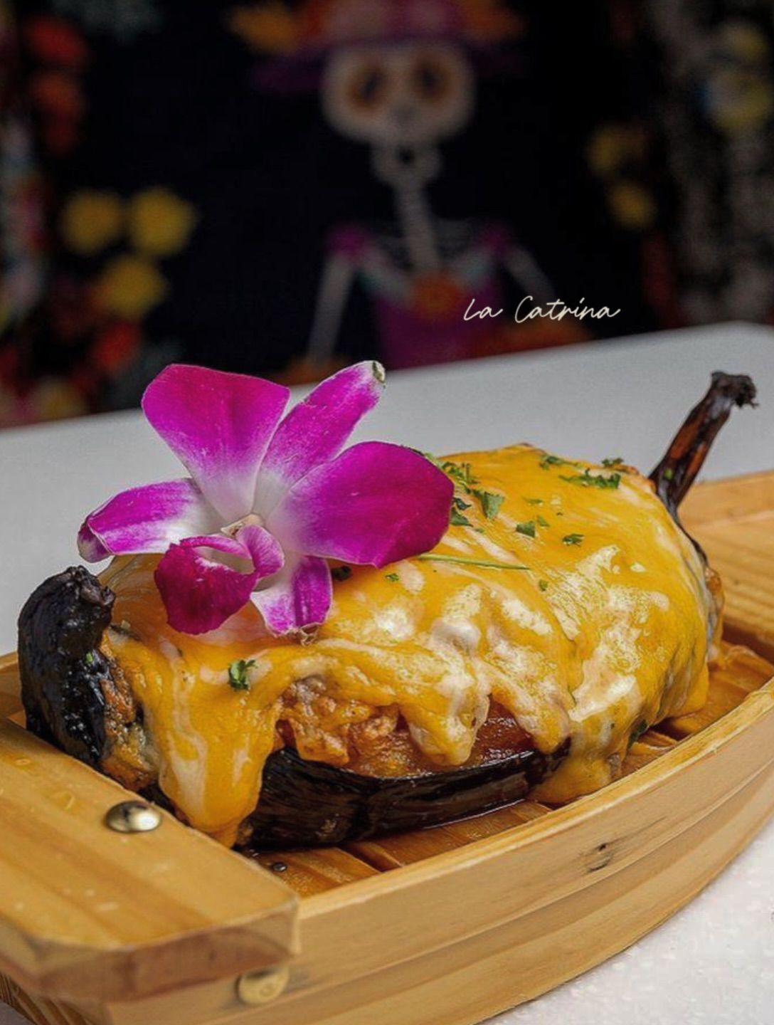 La Canoa — baked sweet plantain stuffed with melted cheese, served on a wooden board