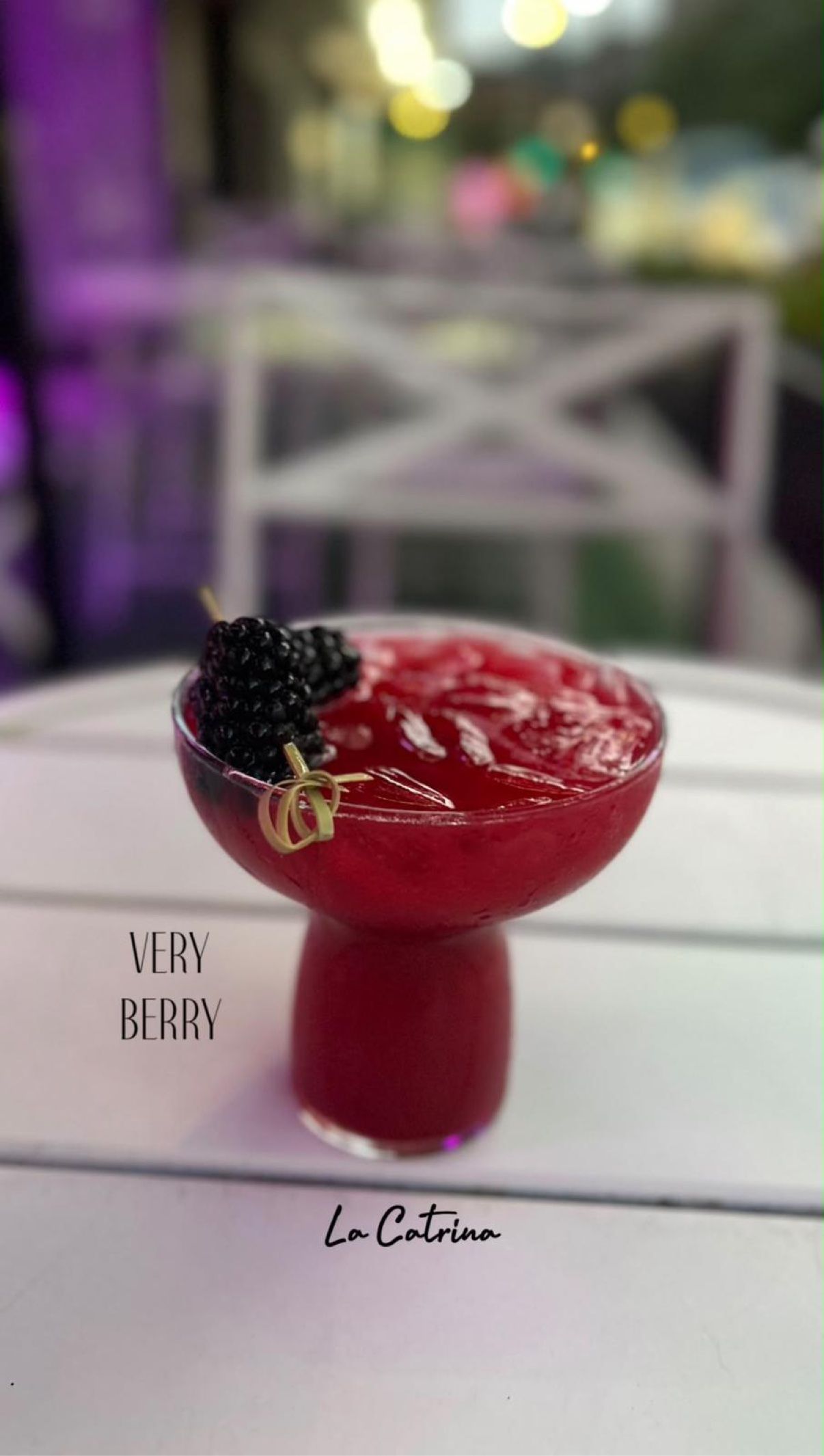 Very Berry — deep-red cocktail crowned with fresh blackberries